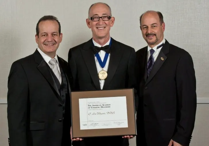 Dr. Lee Wyant, center, holding his AACD Accredited Fellowship certificate.