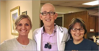 Dr. Wyant with two volunteers at the Harmony Clinic.