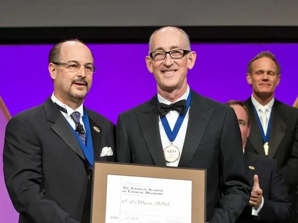 Dr. Lee Wyant on stage receiving his Accredited Fellowship from the American Academy of Cosmetic Dentistry.